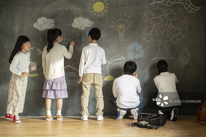 在黑板上画画的孩子们图片素材