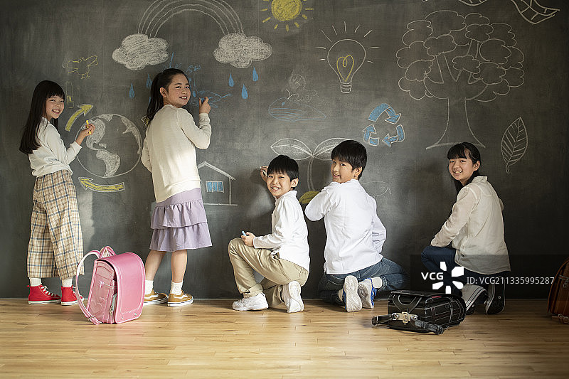 在黑板上画画的孩子们图片素材