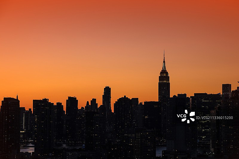 日落时分的天空下的建筑群剪影，美国长岛市图片素材
