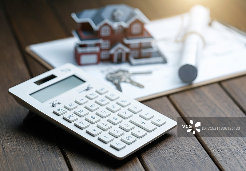 别墅房屋模型,钥匙和图纸放在复古桌面上图片素材