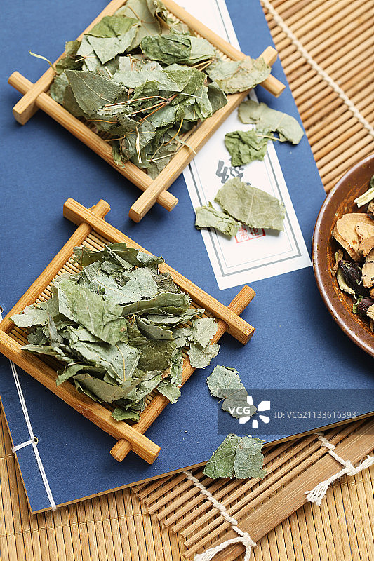 中药淫羊藿放在线装书背景上图片素材