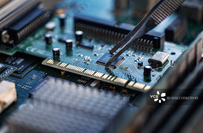 电路板上镊子夹着芯片图片素材