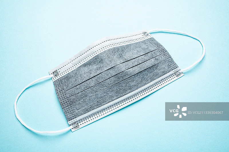 蓝色背景上的活性炭一次性口罩图片素材