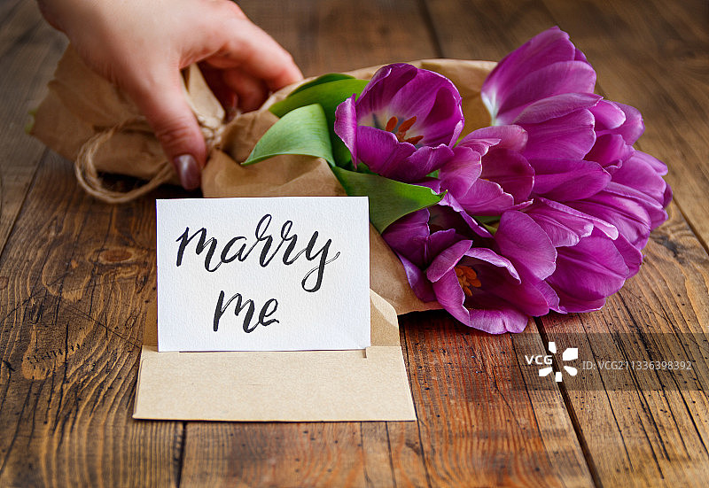 手持鲜花和MARRY ME卡片图片素材