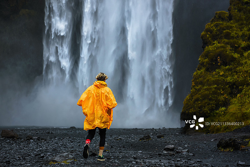 穿着黄色雨衣走向斯科加瀑布的游客图片素材
