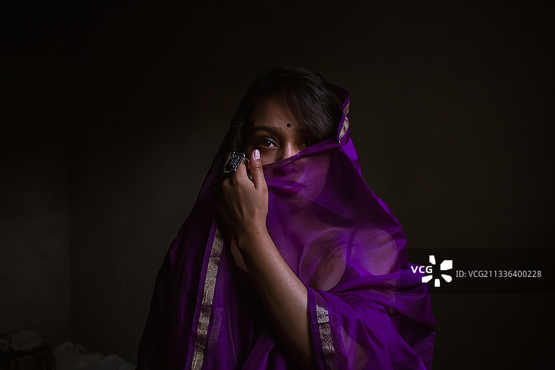 黑色背景下的紫色纱丽女人 портрет图片素材