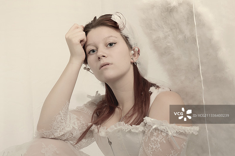 身穿婚纱坐在墙边的年轻女人肖像，德国锡根图片素材