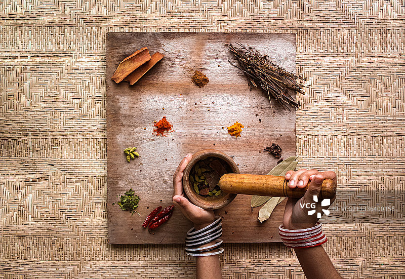 在孟加拉国达卡，女人在桌子上研磨香料图片素材