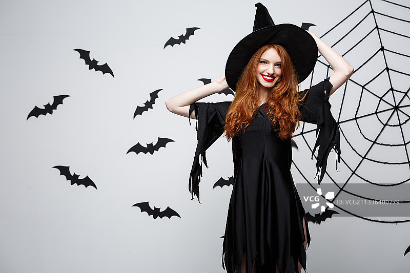 身穿万圣节服装站在白色背景前的女人肖像图片素材