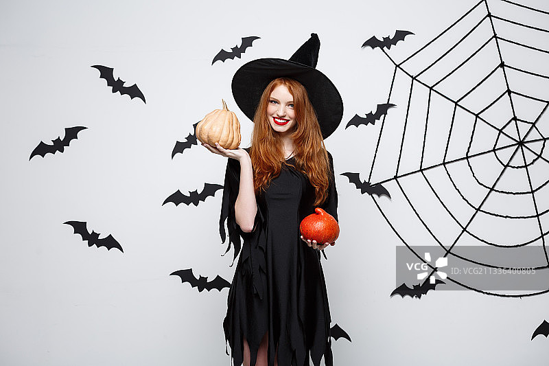 身穿万圣节服装站在白色背景前的女人肖像图片素材