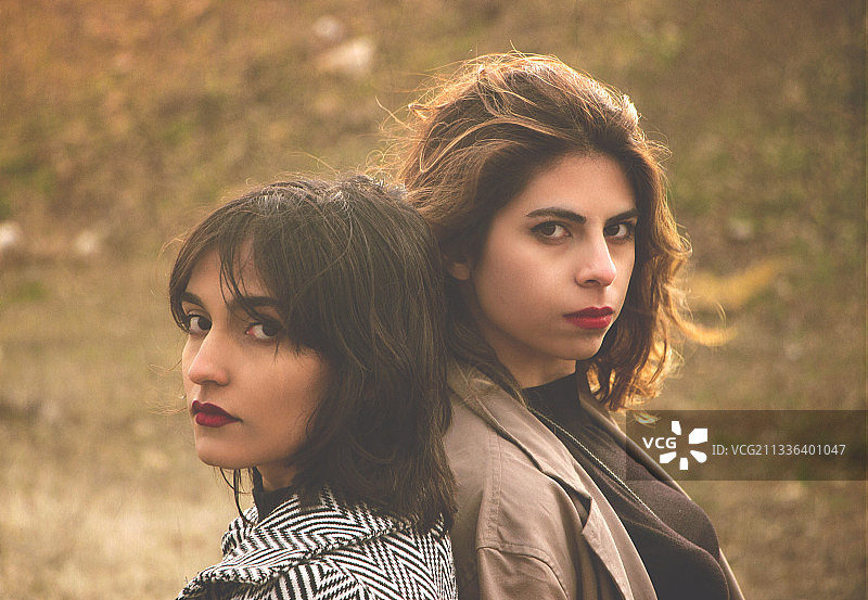 年轻女性与朋友在田野上的合影图片素材