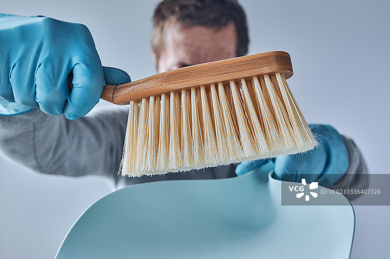 准备打扫房屋：拿着簸箕和刷子的男人，塞尔维亚图片素材