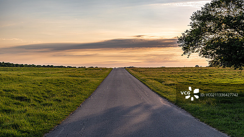 日落时分田野间的空旷道路图片素材