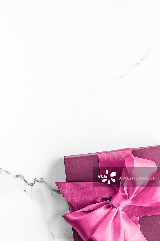 粉色礼品盒，丝绸蝴蝶结，大理石背景，女宝宝欢迎派对图片素材
