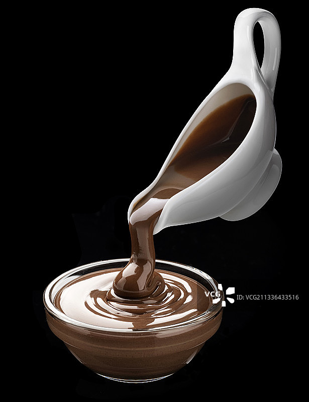 在黑色背景上倾倒融化的巧克力图片素材