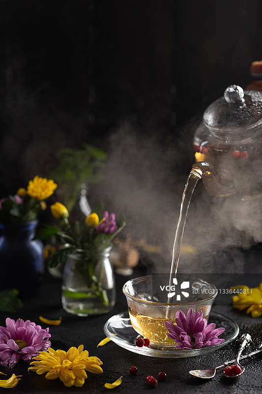泡茶过程：清澈茶壶中倒出热茶的蒸汽图片素材