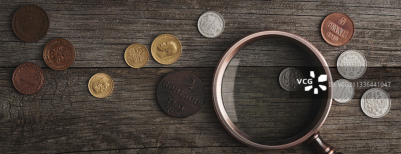 古钱币：木桌上的银制古董收藏币图片素材