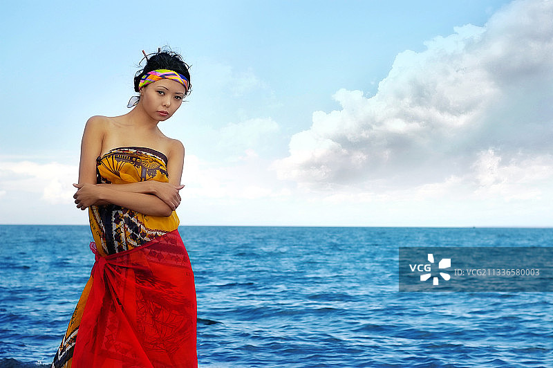 年轻模特站在海边，背景是蓝天白云图片素材