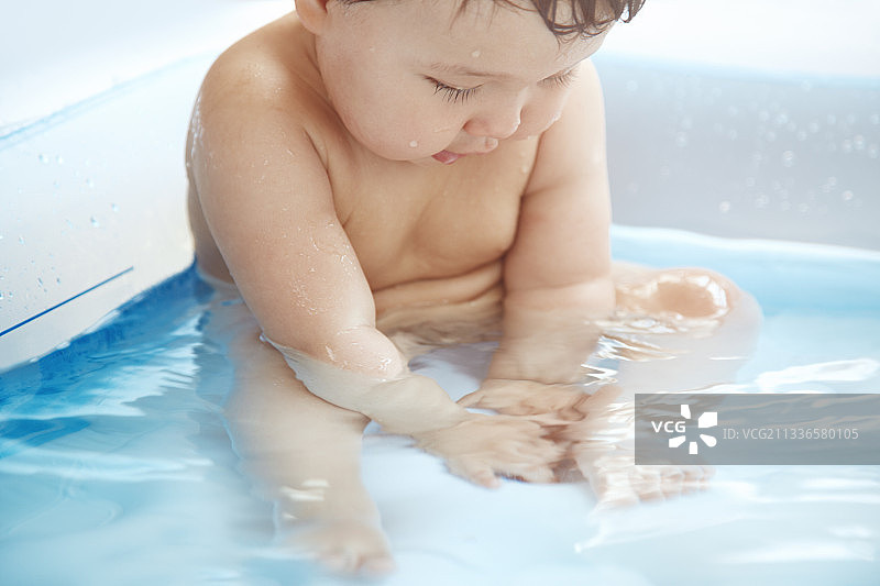 可爱宝宝在游泳池浅水区玩水图片素材