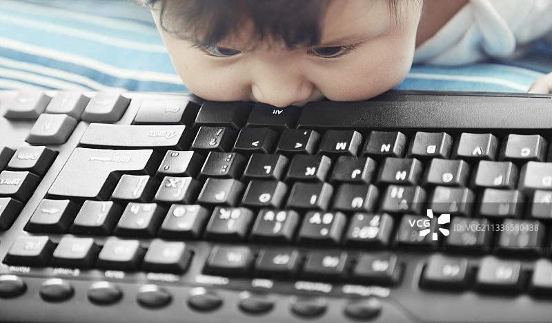 宝宝啃咬电脑键盘，像磨牙玩具图片素材
