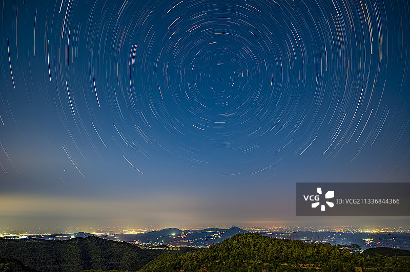 远方城镇上空的星轨图片素材