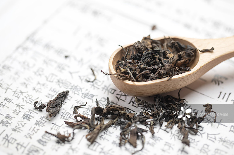 茶经上摆放着红茶茶叶及茶则图片素材