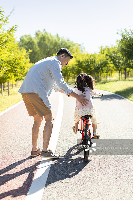 父亲教女儿骑自行车图片素材