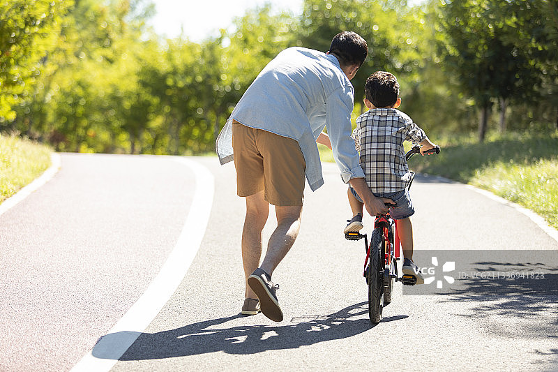 父亲教儿子骑自行车图片素材