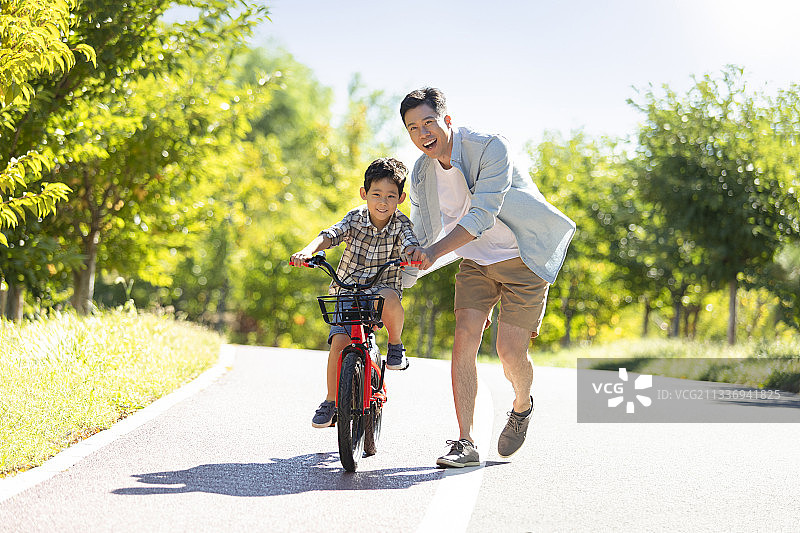 父亲教儿子骑自行车图片素材