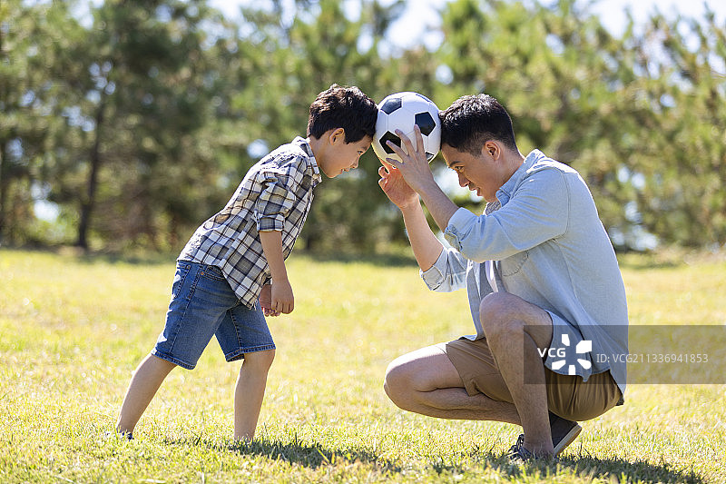 快乐的父子俩在草地上玩耍图片素材