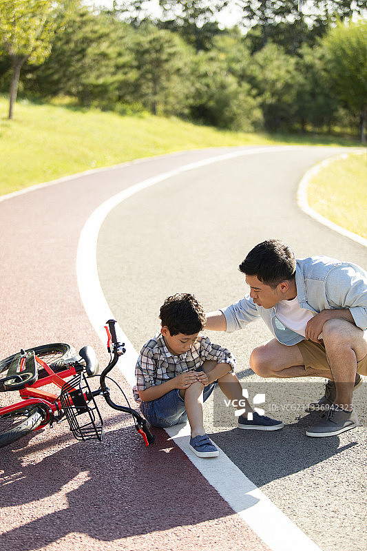 小男孩骑自行车摔倒了图片素材