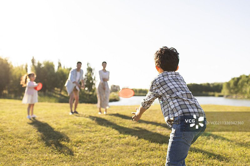 快乐的年轻家庭在草地上嬉戏图片素材
