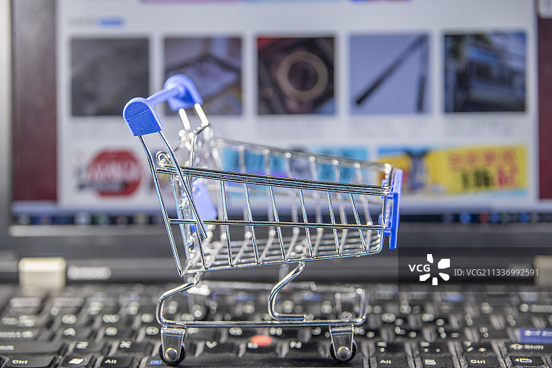 电脑键盘上放着购物车图片素材