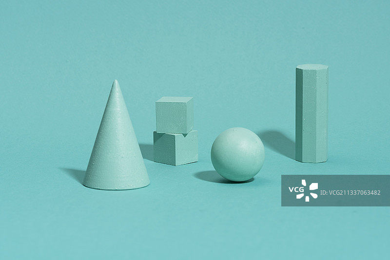 蓝绿色背景上的三维形状图片素材