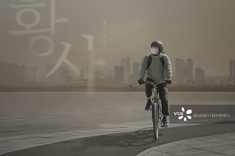 亚洲送货员骑自行车在黄色尘土中穿行图片素材