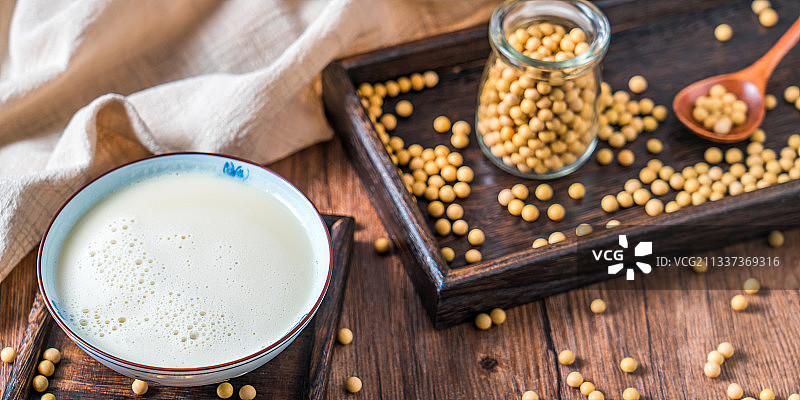 洒在桌面上的许多大豆和一碗豆浆图片素材