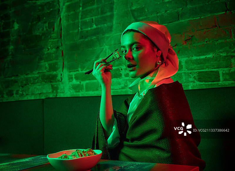 在现代咖啡馆享用午餐的戴珍珠耳环的漂亮女孩图片素材