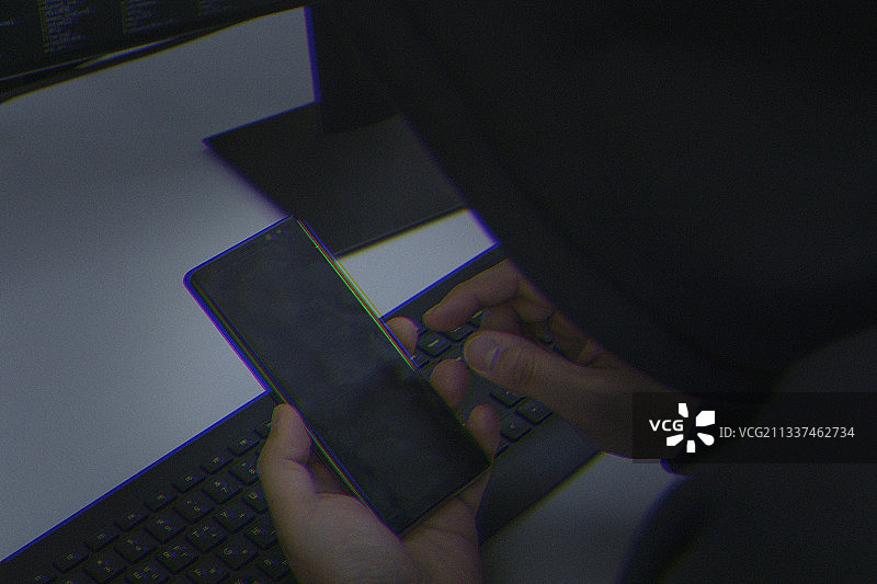 网络犯罪概念，带智能手机的黑客图片素材
