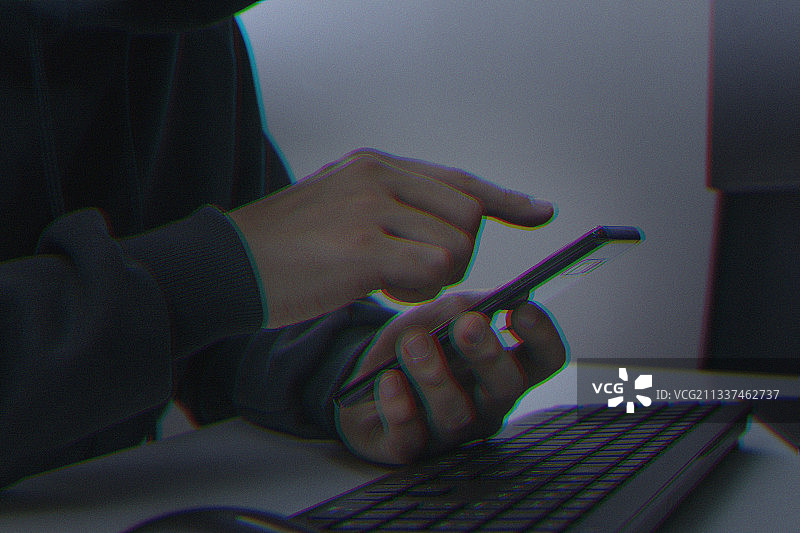 网络犯罪概念，带智能手机的黑客图片素材