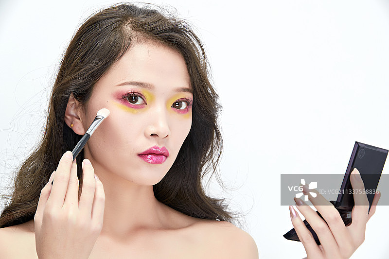 白色背景下棚拍化妆中的美女图片素材