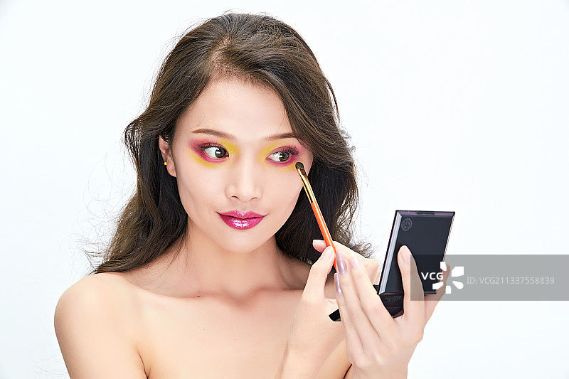 白色背景下棚拍化妆中的美女图片素材