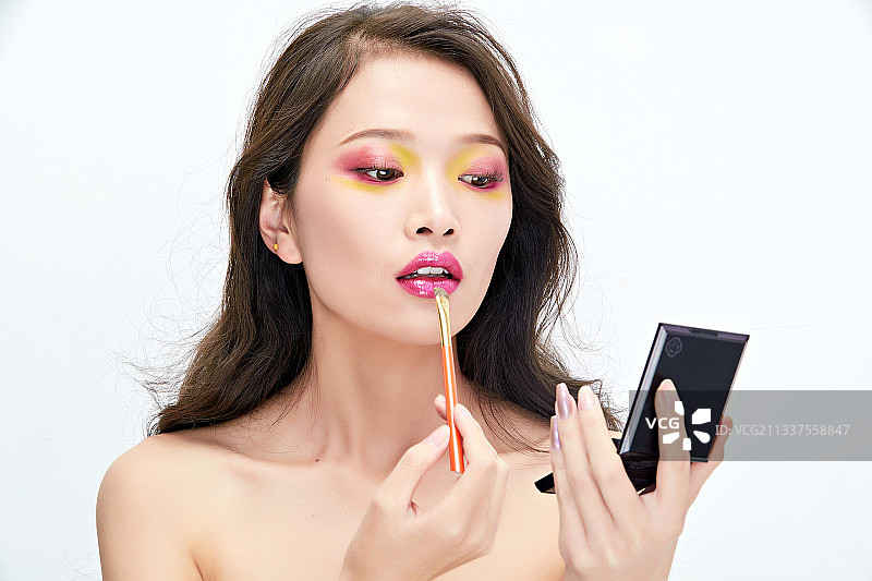 白色背景下棚拍化妆中的美女图片素材