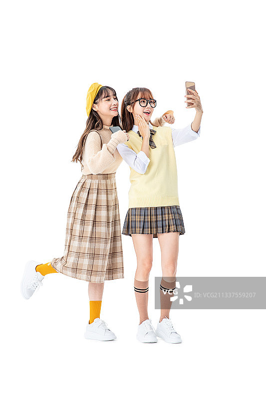 两个女生手拿手机站立图片素材