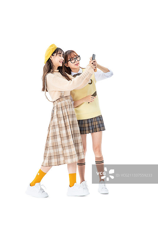 两个女生手拿手机站立图片素材