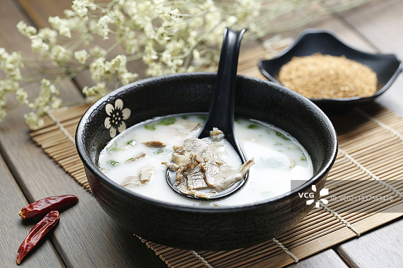 羊汤放在黑色碗里图片素材