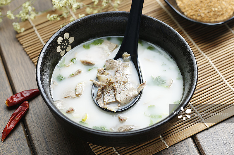 羊汤放在黑色碗里图片素材