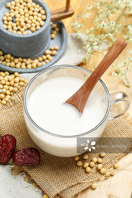 豆浆黄豆和小石磨放在麻布背景上图片素材