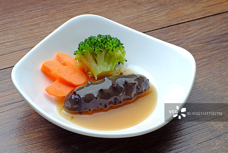 鲍汁海参放在白色盘子里图片素材