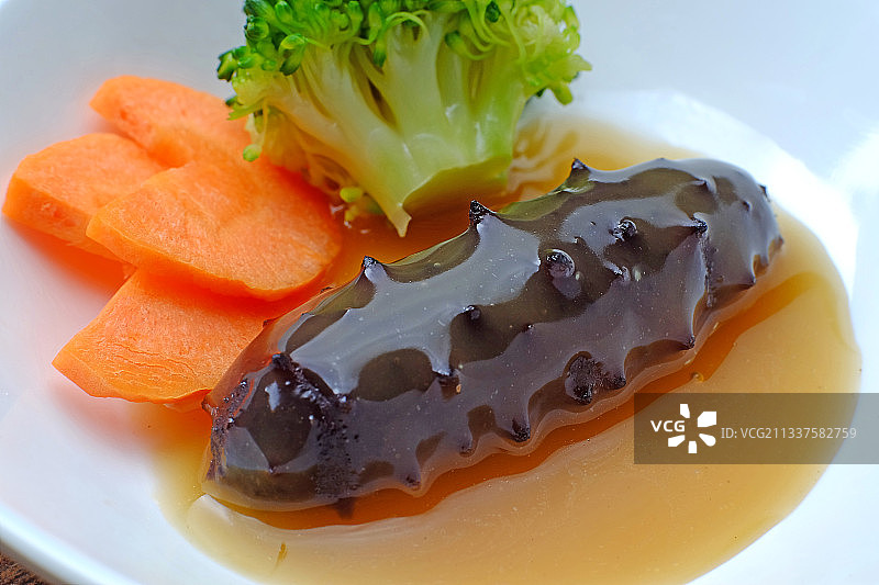 鲍汁海参放在白色盘子里图片素材