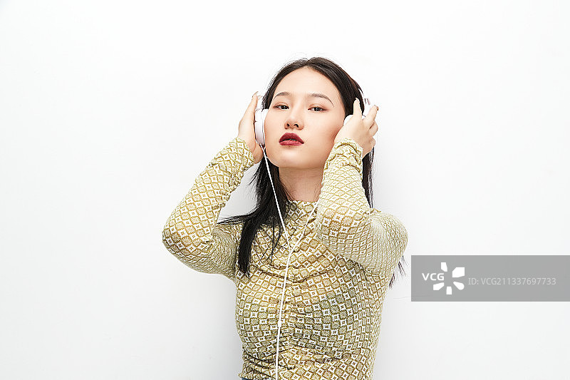 头戴耳机手持电话听音乐的少女图片素材